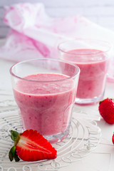 Iced strawberry pink cocktail in a glass and strawberries
