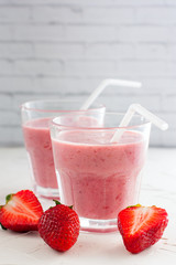 Summer chilled milkshake with strawberries in glass glasses, selective focus