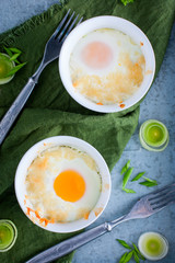 Eggs baked in portioned ramekin with onion, top view, selective focus