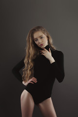 Fototapeta premium Model test with awesome woman in black body over a grey studio background