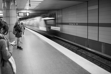 Fahrende  U-bahn in münchen mit wartenden leuten