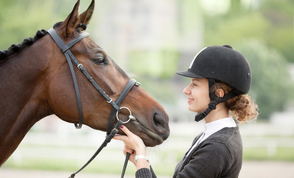Attractive Young Woman Looking at her Horse