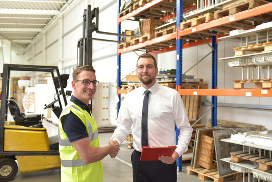 Handschlag Manager und Mitarbeiter  in der Logistik/ Lagerhalle