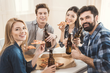 couples drinking beer and eating pizza