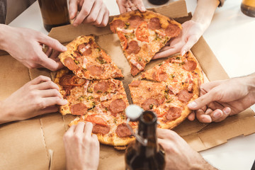 Obraz na płótnie Canvas human hands holding slices of pizza
