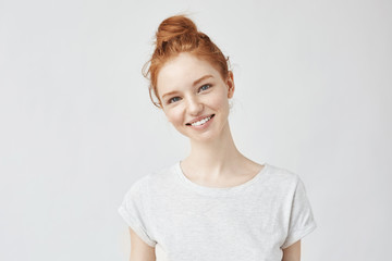 Portrait of young beautiful ginger woman with freckles cheerfuly smiling looking at camera....