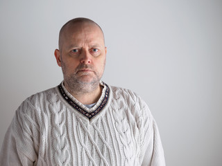 Obraz premium Portrait, casual looking caucasian male wearing a white pullover, he looks toward the camera, copy space is on the right