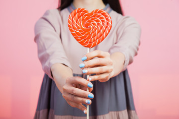 Young woman with heart candy lollipop