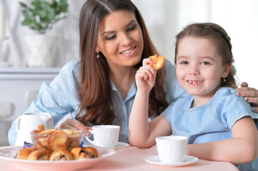 Obraz na płótnie Canvas Mom and daughter having breakfast 