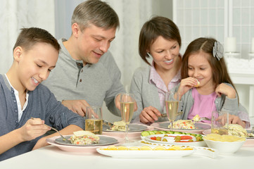 Obraz na płótnie Canvas Happy parents with their children eating 