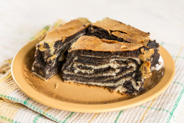 Poppy seed roll cake with copy space over wooden background