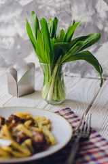 Plate with fried potatoes, bacon and wild garlic