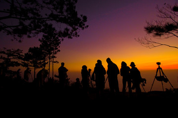 Silhouette of people taking a photo of sunrise