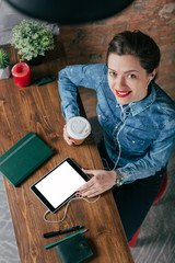Fototapeta na wymiar Beautiful young female freelancer with notepad and tablet have a coffee break in loft interior room