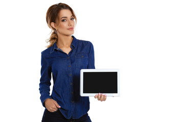 Copy space on her tablet. A cute young woman showing her digital tablet and smiling while standing on a white background