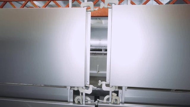 Manufacture. Process of anodizing aluminum products  in production, Immersion of aluminum plates in liquid. Automatic production line.  4k footage. 
