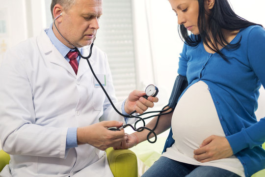 Doctor measures the pressure of a pregnant woman