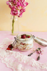 Obraz na płótnie Canvas Oatmeal in a jar with strawberries and coconut on a yellow background