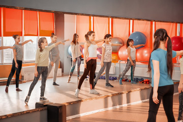 Children healthy lifestyle concept - group of sportive of teenage girls exercising in the gym