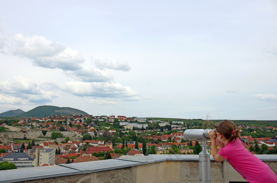 little girl looking through sightseeing binoculars on Eger Hungary