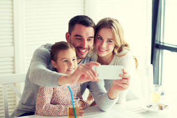 happy family taking selfie at restaurant