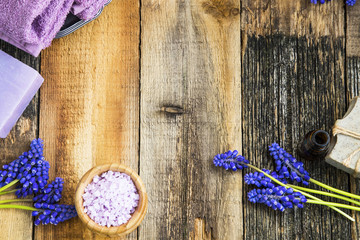 Spa and aromatherapy oil, pruple flowers, soap, bath salt on wooden background, top view