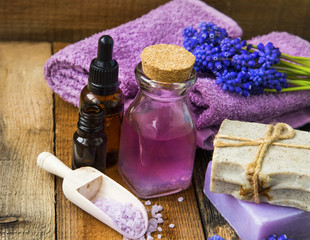 Fototapeta na wymiar Spa and aromatherapy oil,towels, purple flowers, soap, bath salt on wooden background