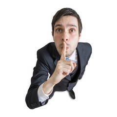 Young man is showing be quiet gesture. View from above. Isolated on white background.