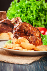 Roasted turkey knuckle with fried potato slices