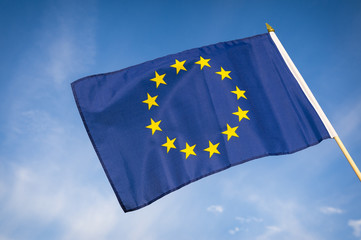 Single European Union flag flying in bright blue sky 