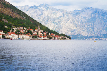 Old small town on sea coast. Village close to bay against mountains background