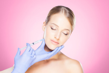 Fototapeta premium Doctor injecting in a beautiful face of a young woman. Plastic surgery concept.