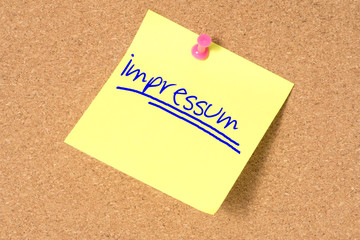 Ein Zettel mit dem Wort Impressum an einer Pinnwand