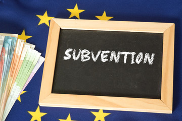 Flagge der EU, Euro Geldscheine und eine Kreidetafel mit dem Wort Subvention