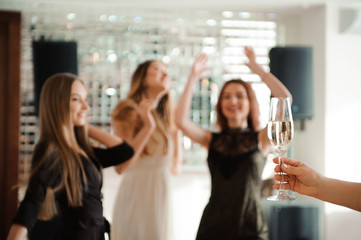 Group people with champagne dancing at the party.