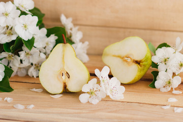 The ripe pear and the blossom on the wooden table