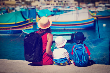 mother and two kids looking at traditional boats in Malta