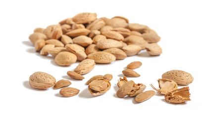 Lots of Almond nut in shell, shelled and some broken shells isolated on white background close up selective focuswith beautiful bokeh effect