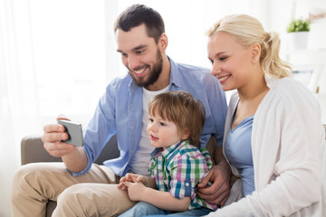 Obraz premium happy family with smartphone at home