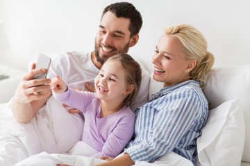 happy family taking selfie by smartphone at home