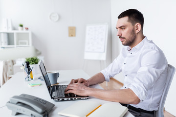 businessman typing on laptop at office
