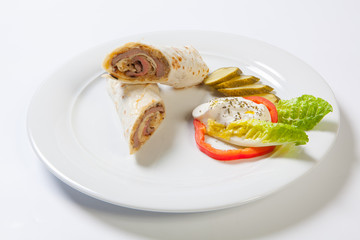 Rolls from pita bread stuffed with beef and onion decorated with vegetables