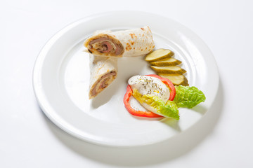 Rolls from pita bread stuffed with beef and onion decorated with vegetables