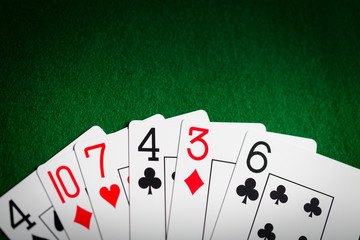 poker hand of playing cards on green casino cloth