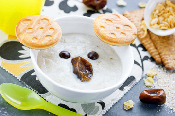 Oat bran porridge with cookies, chocolate and dates shaped cute koala