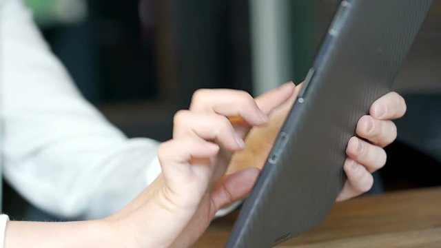 Girl's hands touching screen on tablet while browsing internet, steadycam shot
