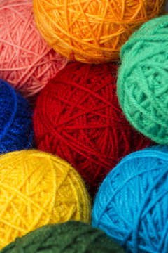 Woolen yarn balls, skeins of tangled colorful sewing threads, selective focus