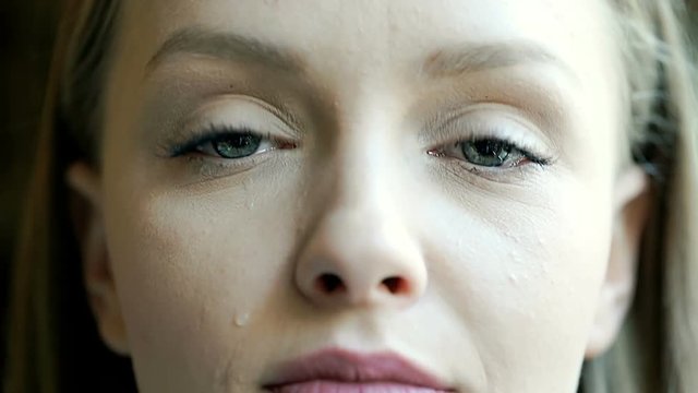 Beautiful girl looking to the camera and crying because of sadness
