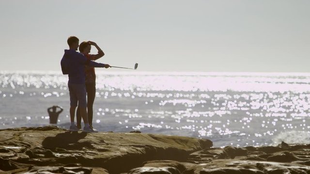 Brother and sisiter are taking a selfie on a coast
