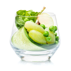 Pieces of apple, grapes and cucumber in a glass